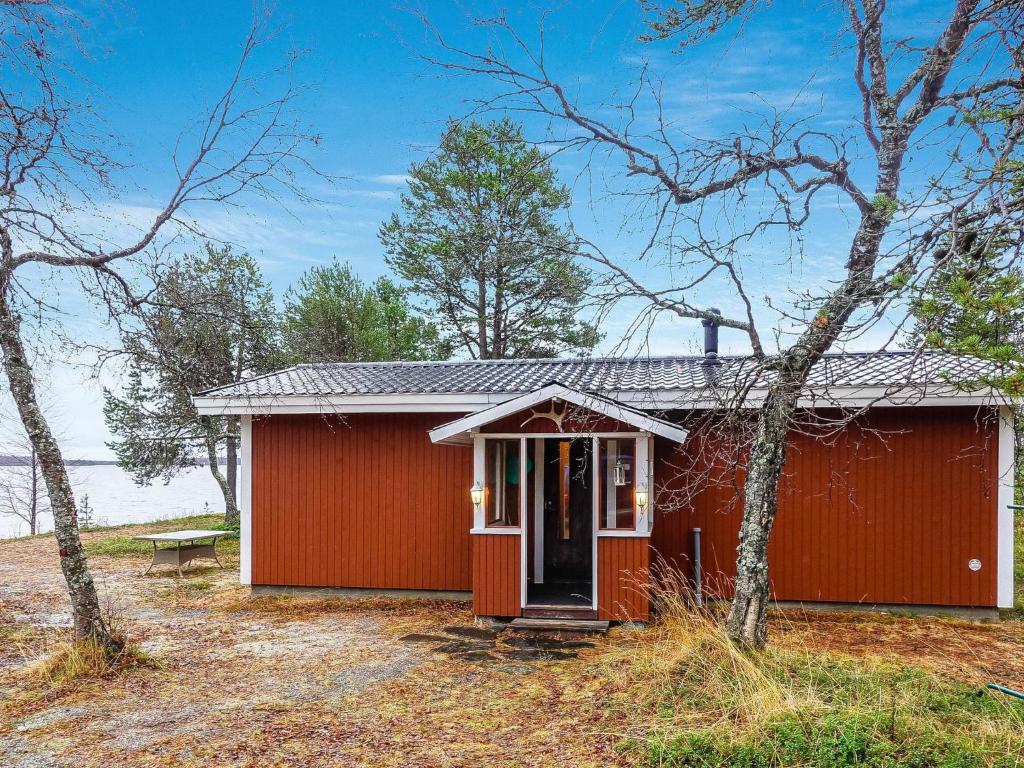 a red shed with a red door in the woods at Holiday Home Mellaniemi by Interhome in Hietajoensuu