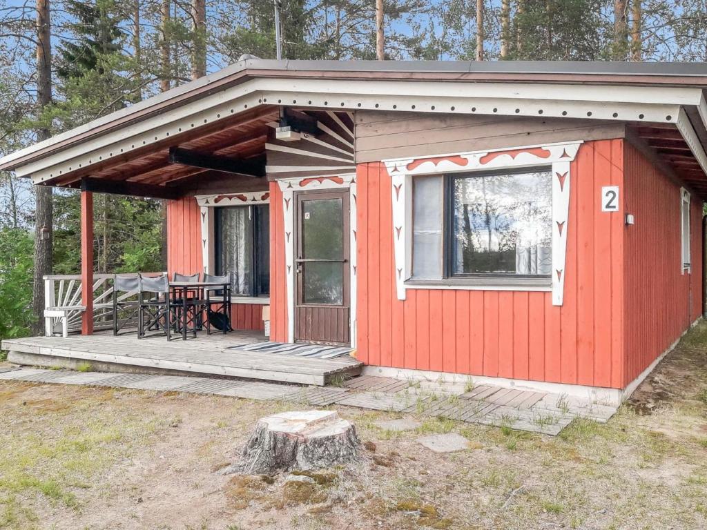 uma cabina vermelha com uma mesa num deque em Holiday Home Hiekkasaari by Interhome em Juhanala