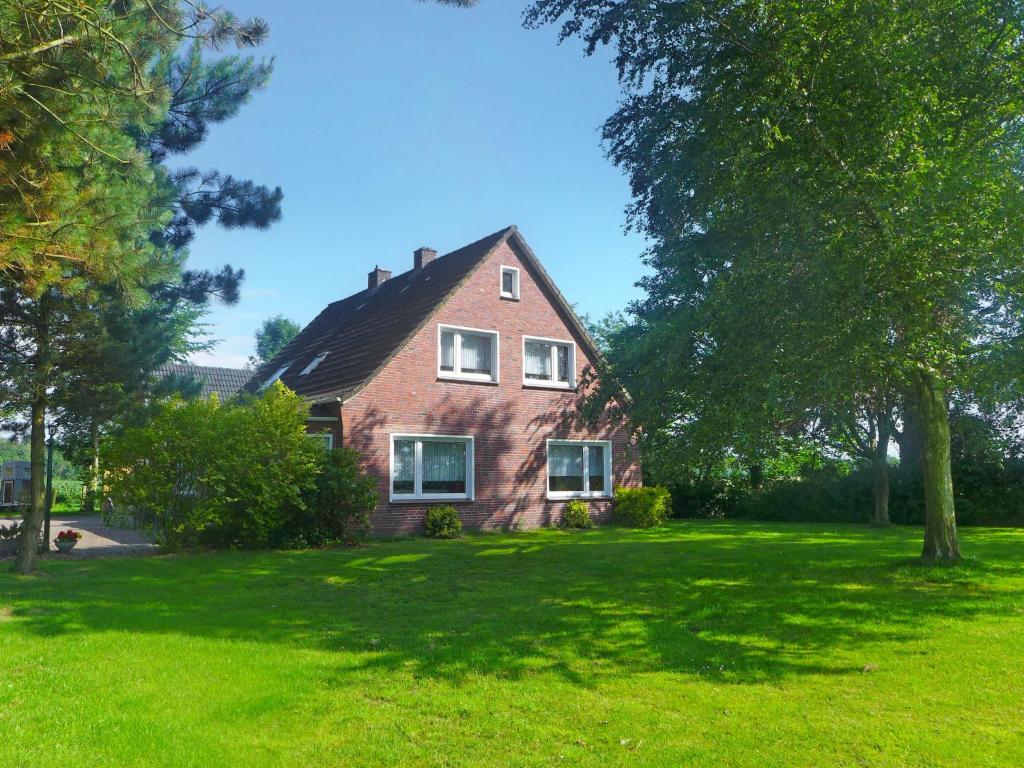 ein Haus auf einem grünen Rasen mit einem Baum in der Unterkunft Apartment Landblick-1 by Interhome in Süderneuland Zwei