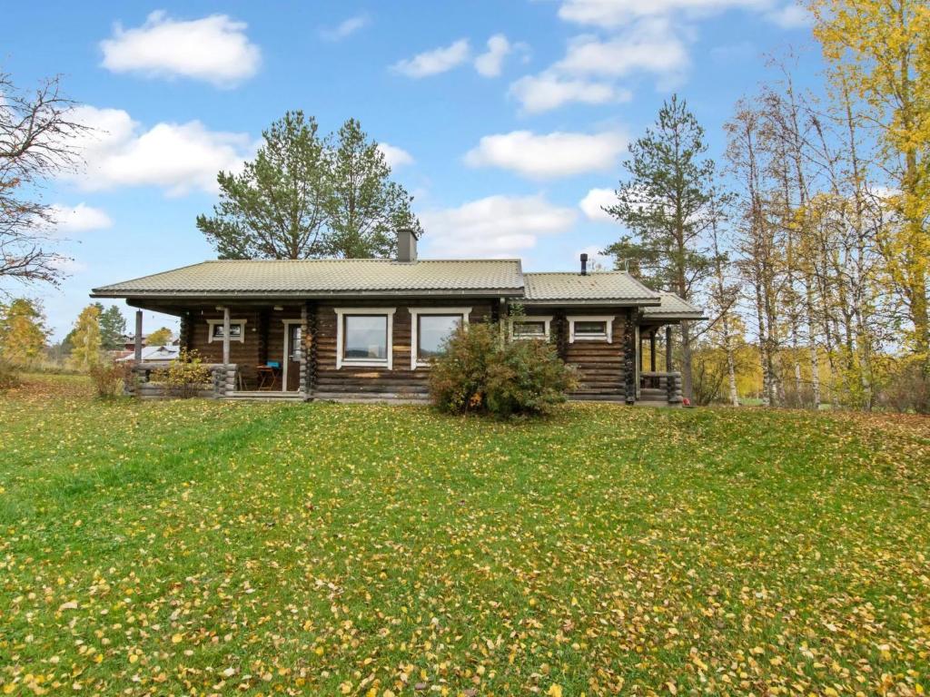 a log house on a hill with a yard at Holiday Home Pihlajakumpu by Interhome in Petäjävesi