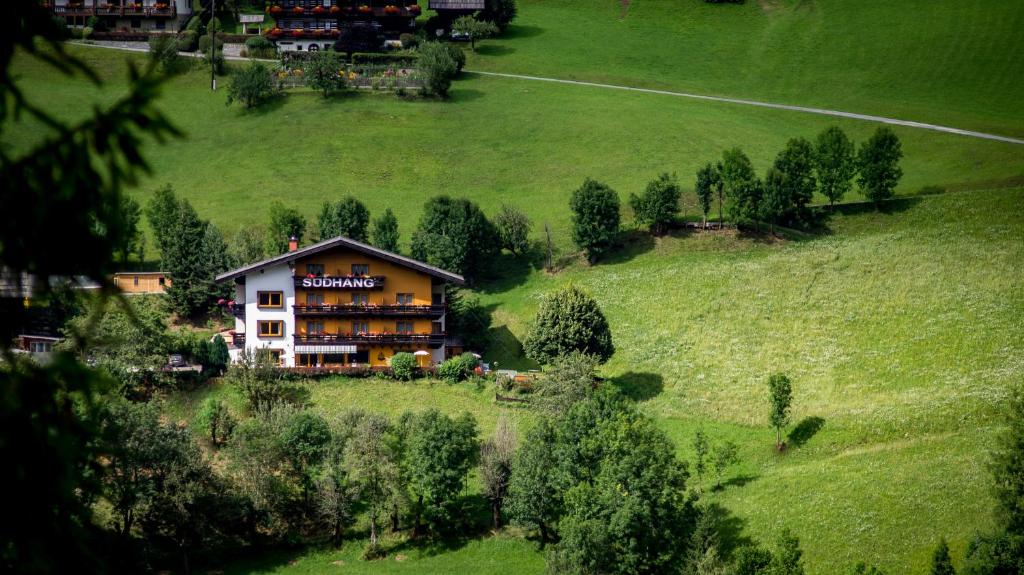 a large building on a hill with a green field at Pension Südhang in Bad Kleinkirchheim