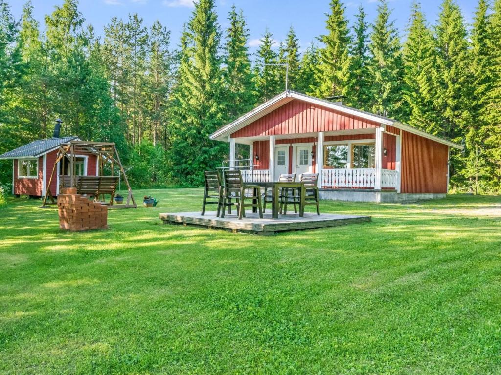 a small cabin with a picnic table in a yard at Holiday Home Laavusranta by Interhome in Kantala
