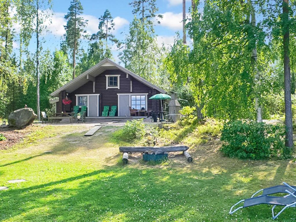 una piccola casa con una panchina davanti di Holiday Home Beach 2 - 5664 by Interhome a Vääksy