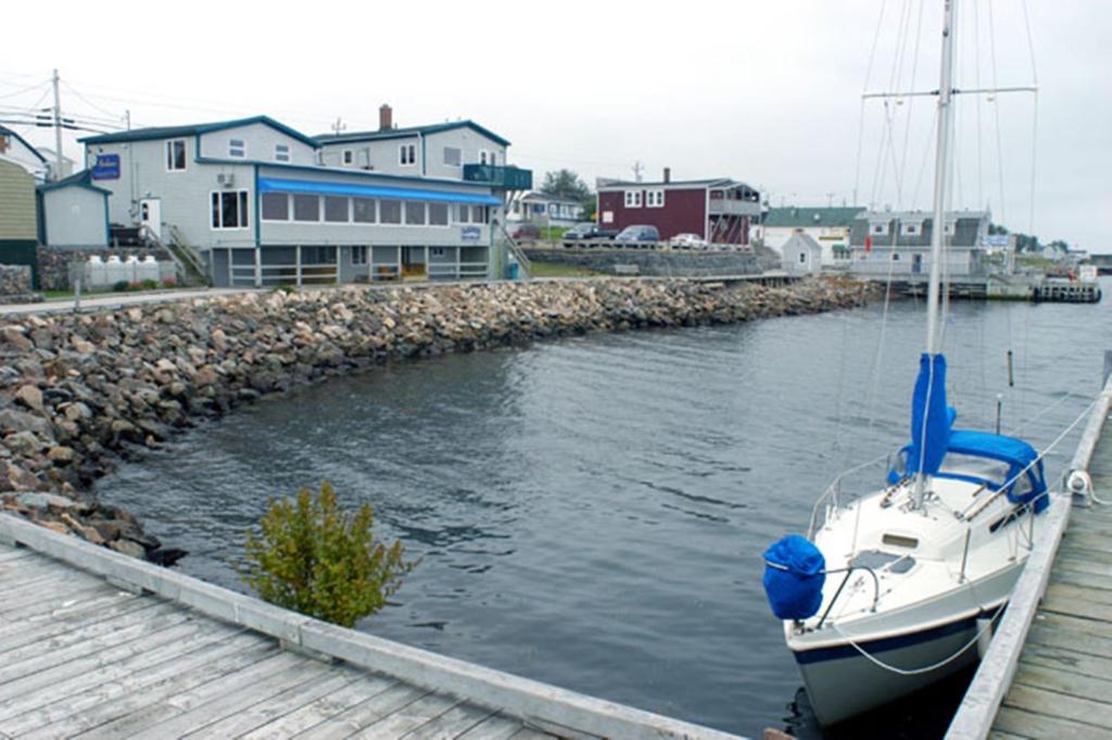 a boat is docked at a dock in the water at Auberge Bay Wind Suites in Chéticamp