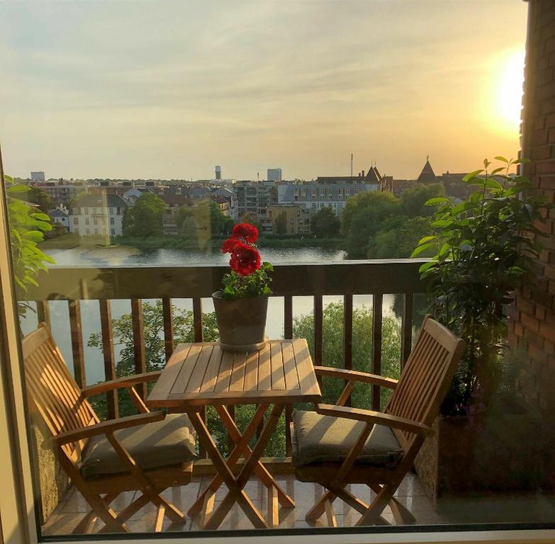 een tafel en stoelen op een balkon met een vaas met bloemen bij ApartmentInCopenhagen Apartment 1442 in Kopenhagen