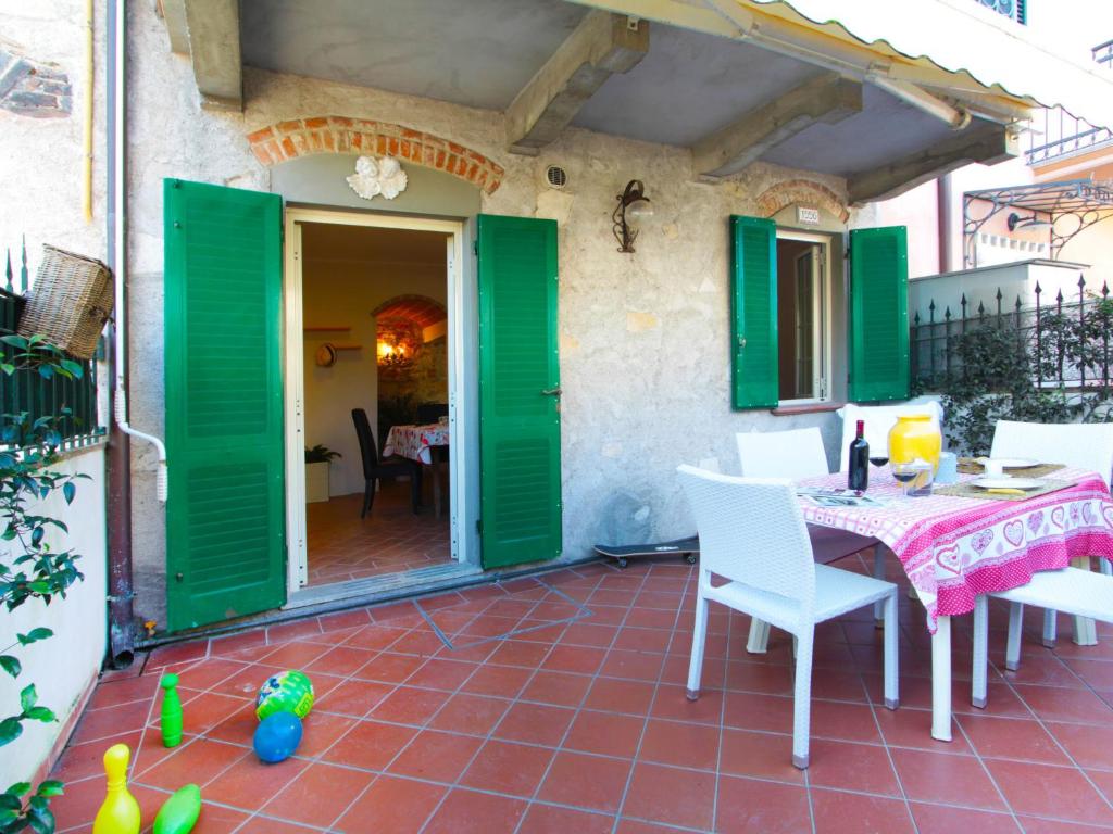 フォルテ・デイ・マルミにあるApartment Gelsomino by Interhomeの緑のドア、テーブル、椅子が備わるパティオ