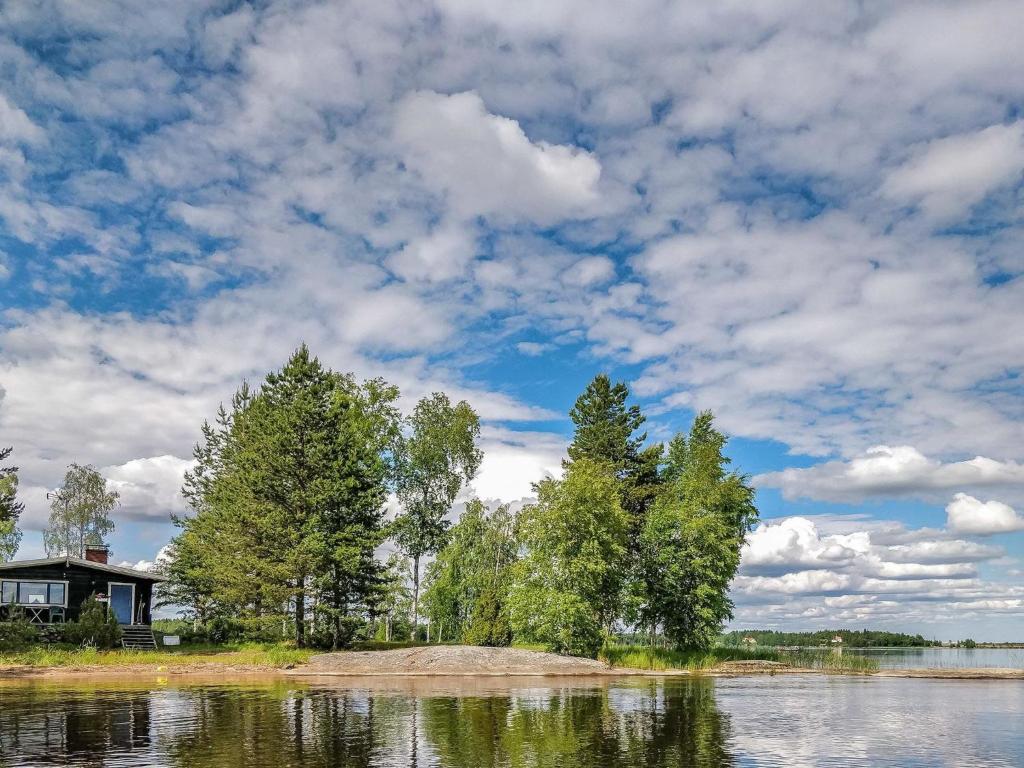 una casa a orillas de un lago con árboles en Holiday Home Inninniemi by Interhome, en Pyhäsalmi