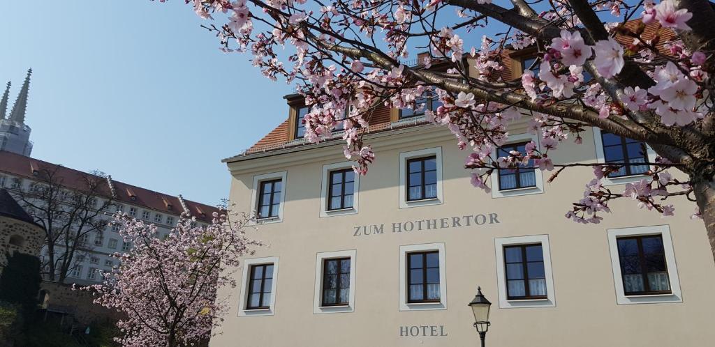 Garni Hotel Zum Hothertor في غورليتز: مبنى ابيض عليه فندق جيم هورنر