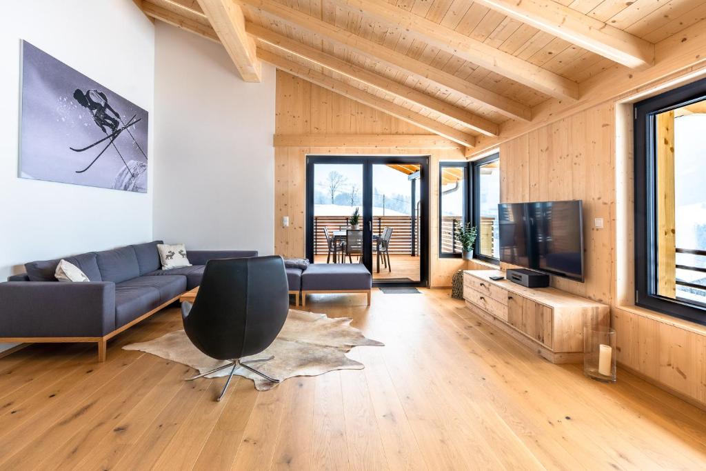 a living room with a couch and a television at Chalet Allgäublick in Sonthofen