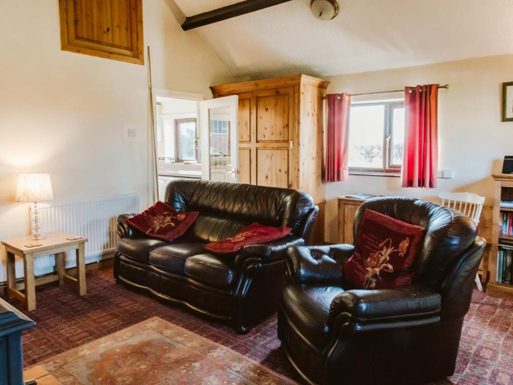 a living room with two leather chairs and a couch at Our Snug in Riccall