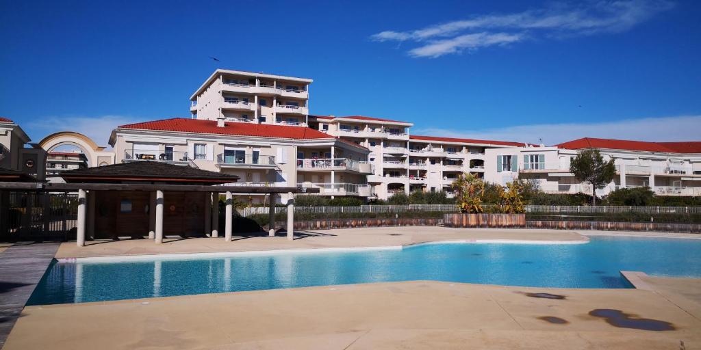 a swimming pool in front of a large building at Appartement Les Alizés in Juan-les-Pins