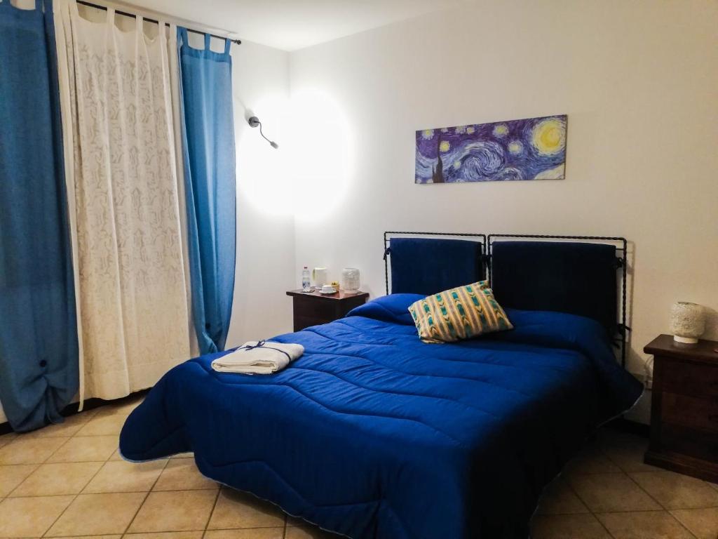 Terre Di Gratia في Camporeale: سرير مع لحاف أزرق في غرفة النوم