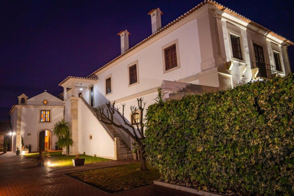 Alpiarça的住宿－Quinta da Atela，夜间有树 ⁇ 的白色房子