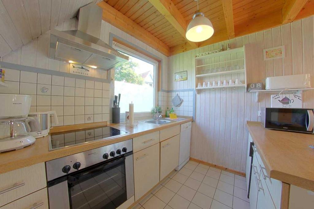 a kitchen with a sink and a stove top oven at SR VS1 Haus Ellie in Dorum-Neufeld