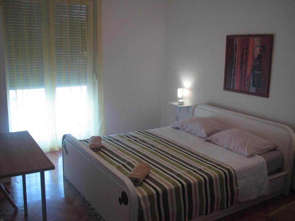 a bedroom with a bed and a table and a window at Apartment Rota in Zadar