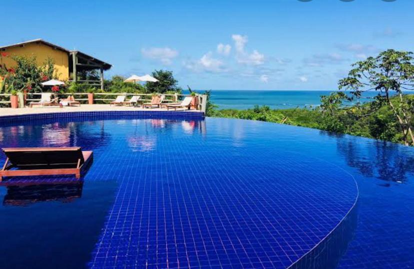 une grande piscine avec vue sur l'océan dans l'établissement VILLAS DO PRATAGY, à Maceió