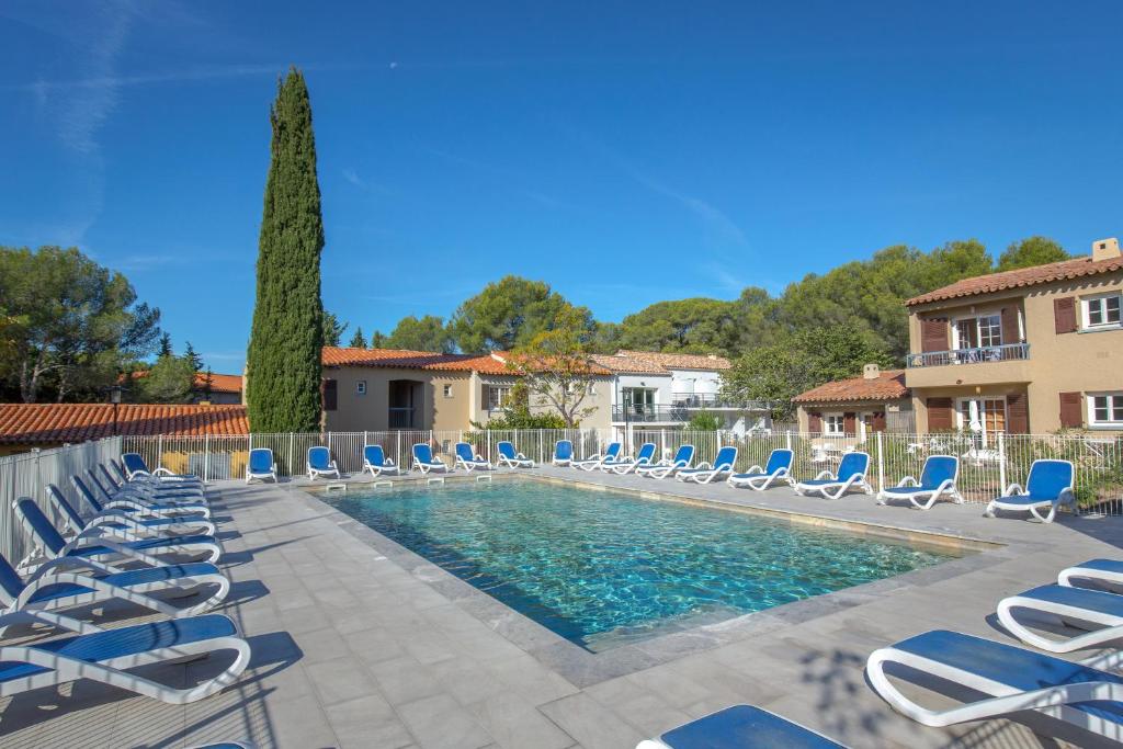 a swimming pool with lounge chairs and a swimming pool at SOWELL RESIDENCES Chênes Verts in Saint-Raphaël