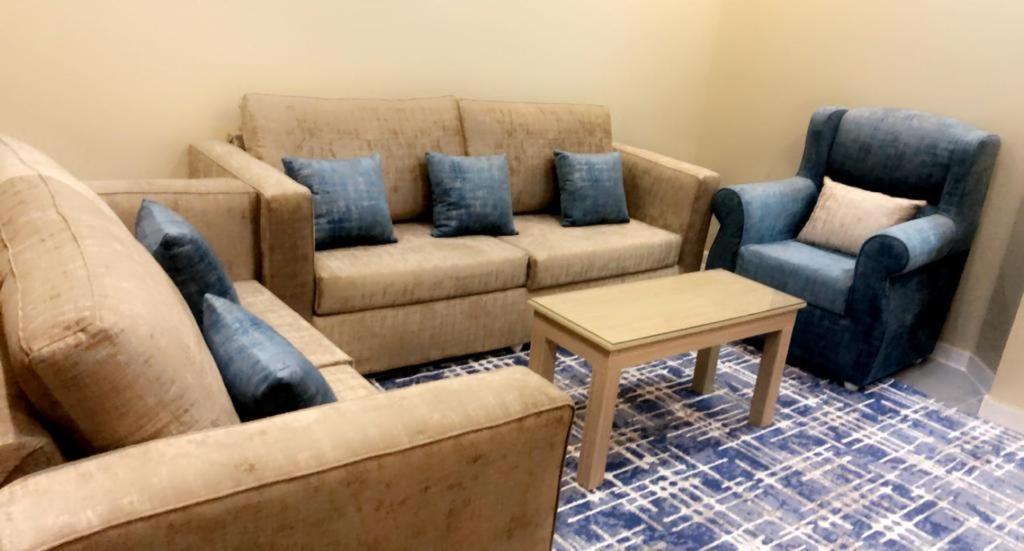 a living room with a couch and two chairs at Marina Arar Furnished Apartments in Arar