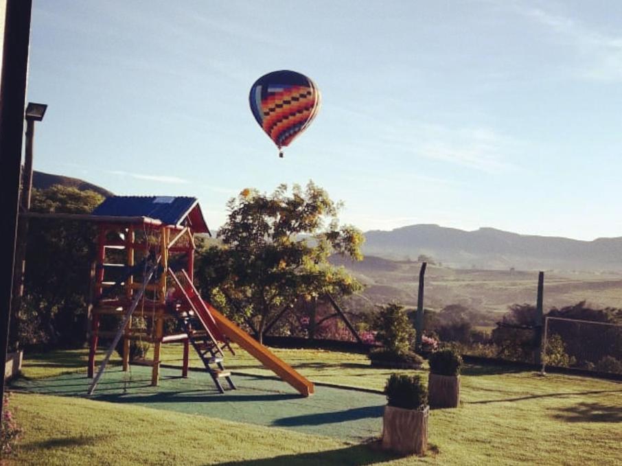 a hot air balloon flying over a playground at Pousada Tia Tuquinha in Piumhi