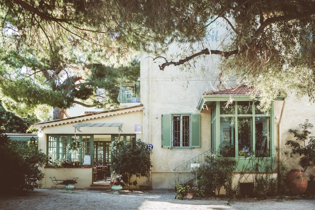 una casa con persianas verdes y una ventana en Hotel Le Ponteil, en Antibes