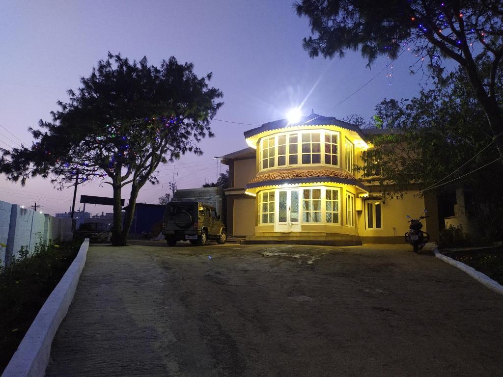 a large yellow building with the light shining on it at Heritage Holiday Home in Ooty