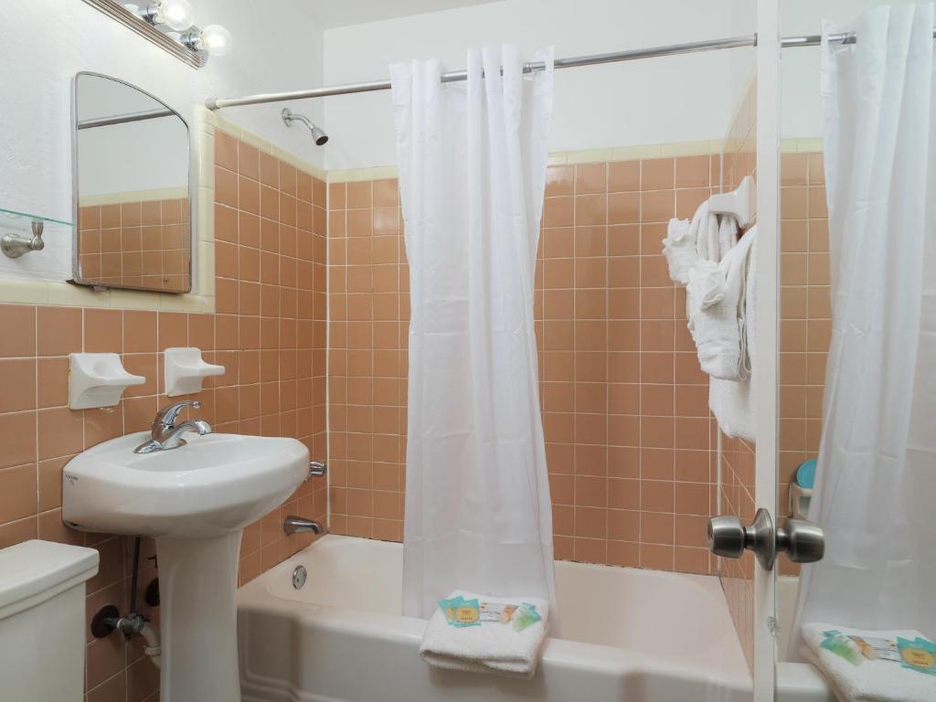 ein Badezimmer mit Dusche, Waschbecken und Toilette in der Unterkunft South Beach Inn - Cocoa Beach in Cocoa Beach