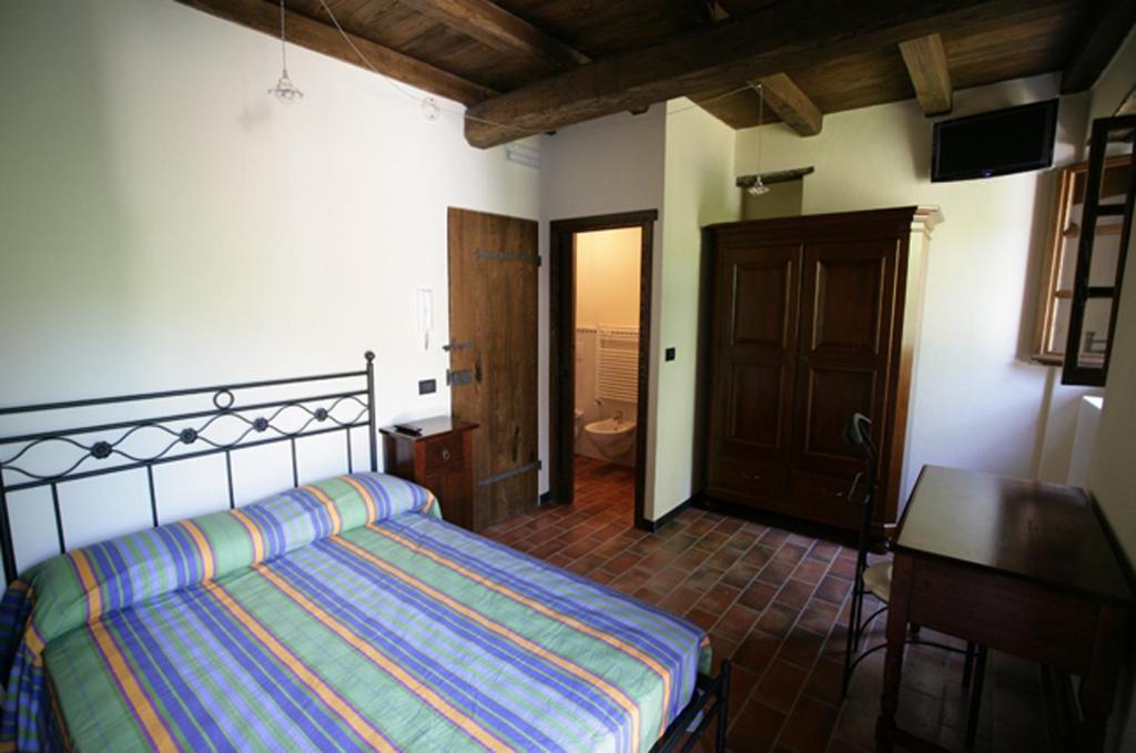 ein Schlafzimmer mit einem Bett und einem Schreibtisch sowie ein Badezimmer in der Unterkunft Affittacamere Dall'Acquarone in Masone