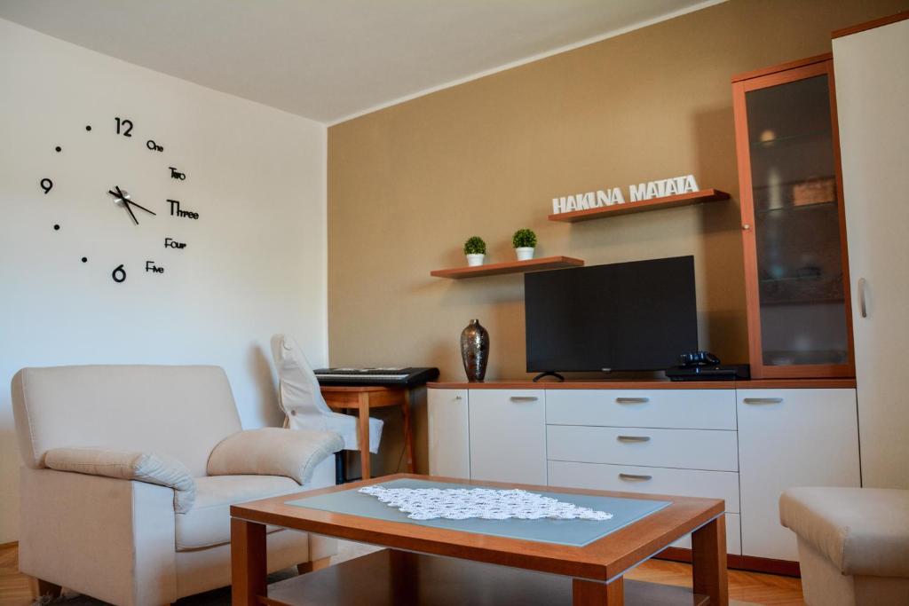 sala de estar con silla, mesa y TV en House Marin - whole house, en Maribor
