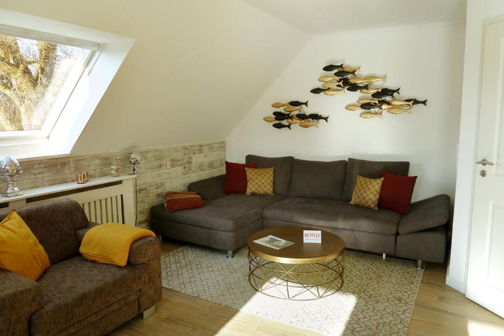 a living room with two couches and a table at Villa am Deich in Westerdeichstrich