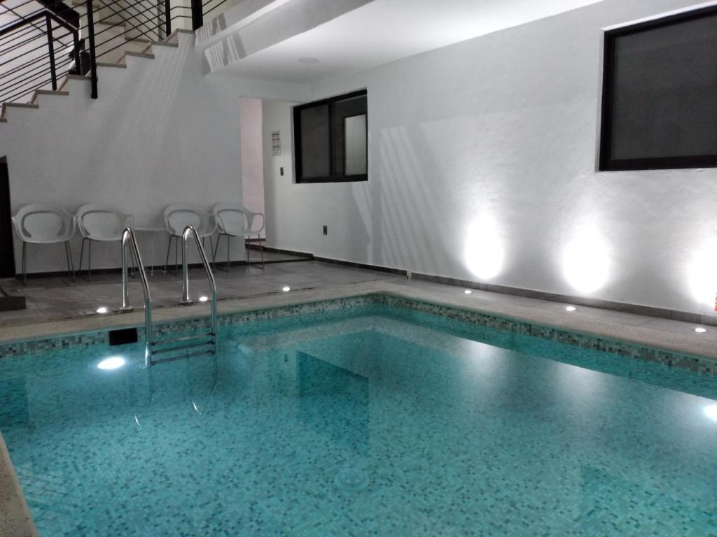 a large swimming pool in a white room with at Venecia 262 in Puerto Vallarta