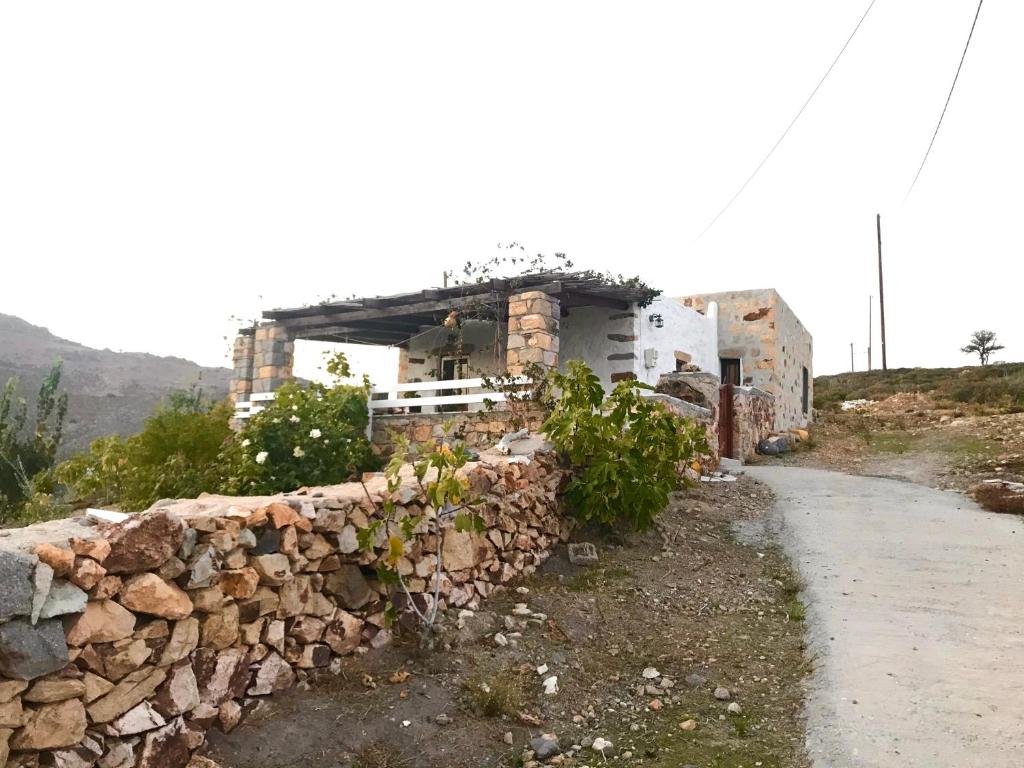 a building with a stone wall next to a road at Chris House in Sapsila