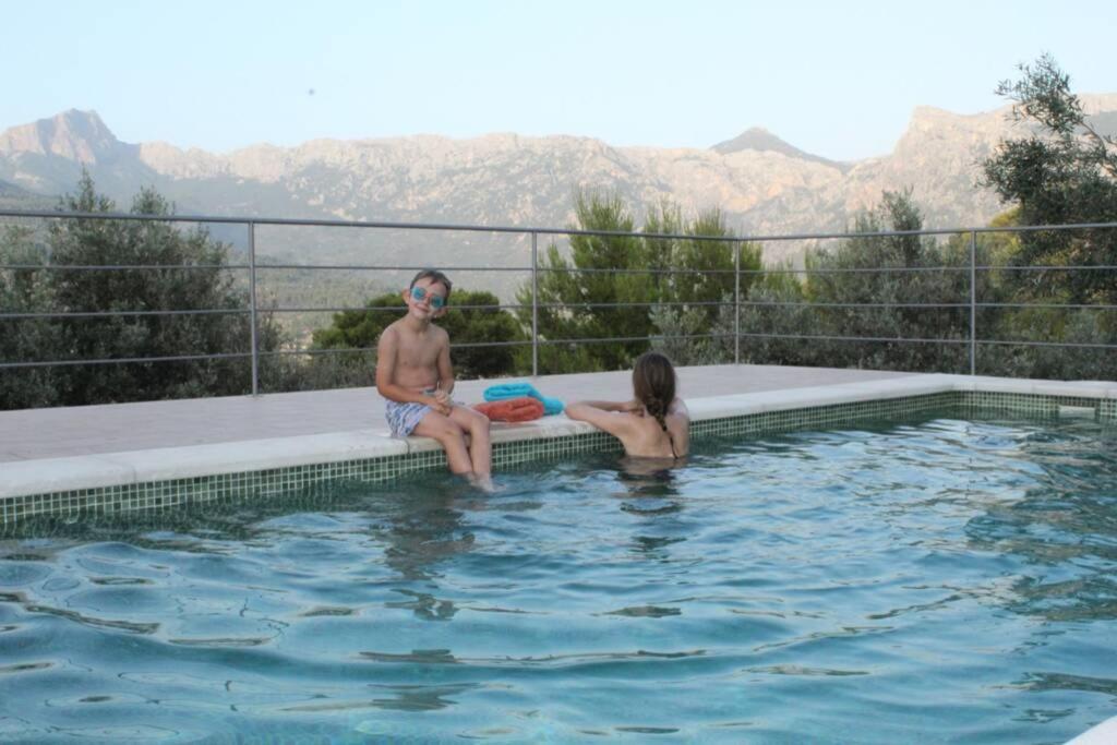 un hombre y una mujer sentados en una piscina en OLIVAR de S’HERETAT Trekking/ruta GR-221 (ETV/2099), en Sóller