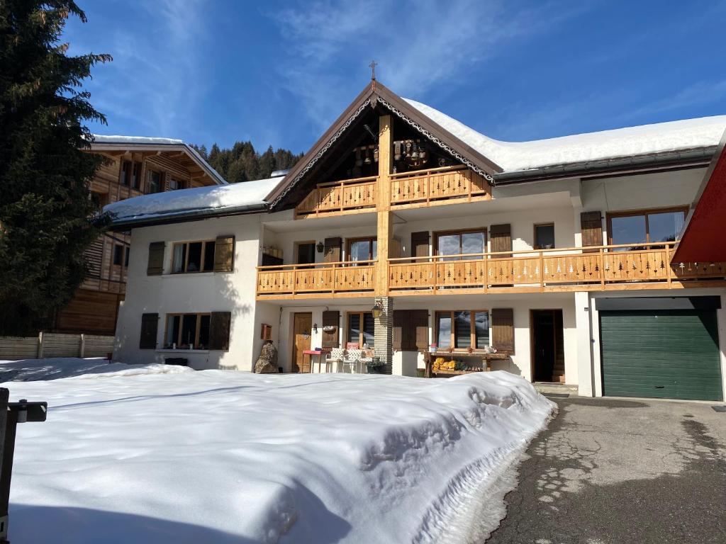 ein großes Haus mit Schnee davor in der Unterkunft Résidences DELAVAY LA FERME in Les Gets