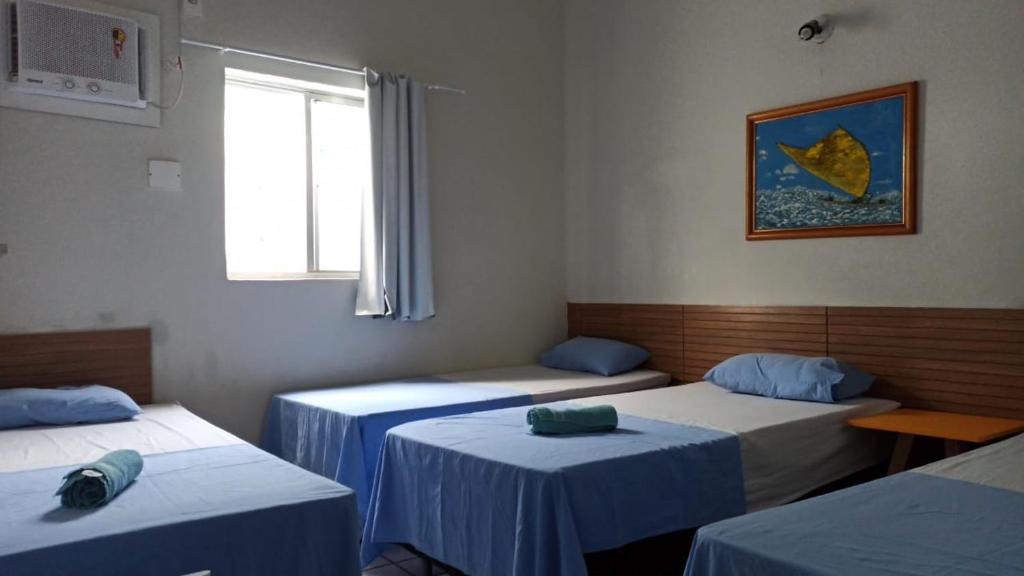 um quarto com três camas e uma janela em Casa do Meio Pousada em Recife