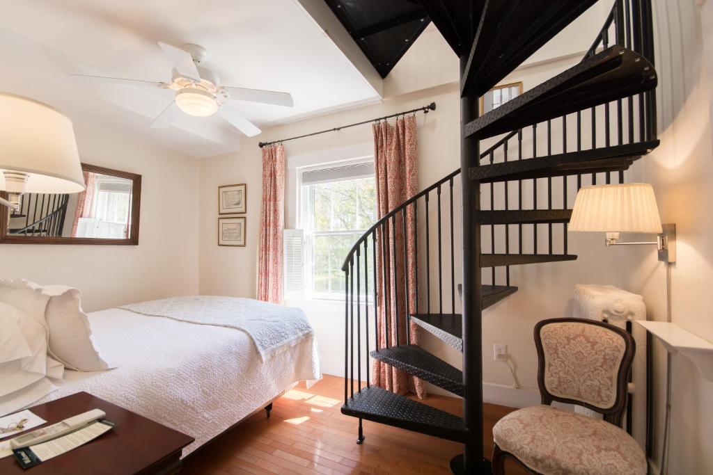 a bedroom with a bed and a spiral staircase at Marshall Slocum Inn in Newport