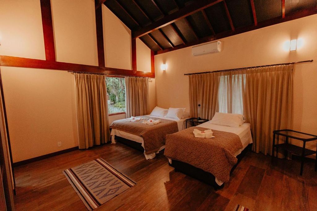 En eller flere senge i et værelse på Chácara Comary