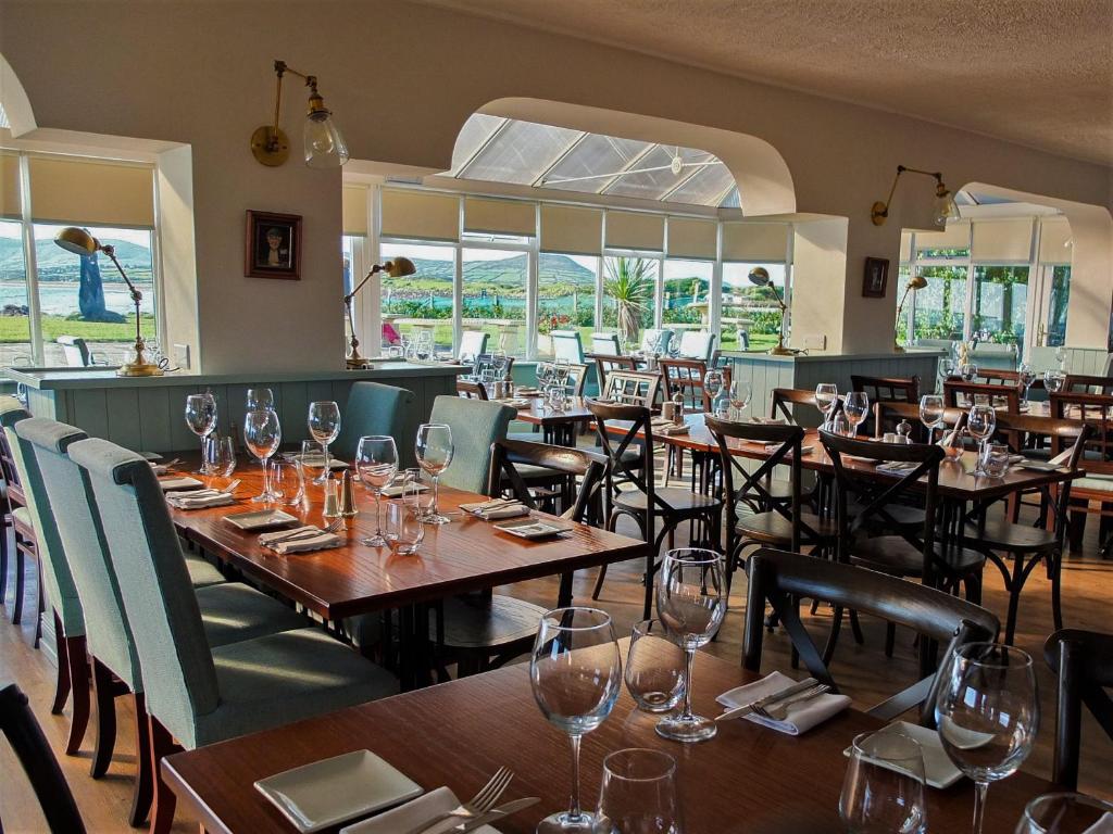 um restaurante com mesas de madeira e cadeiras com copos de vinho em The Smugglers Inn em Waterville