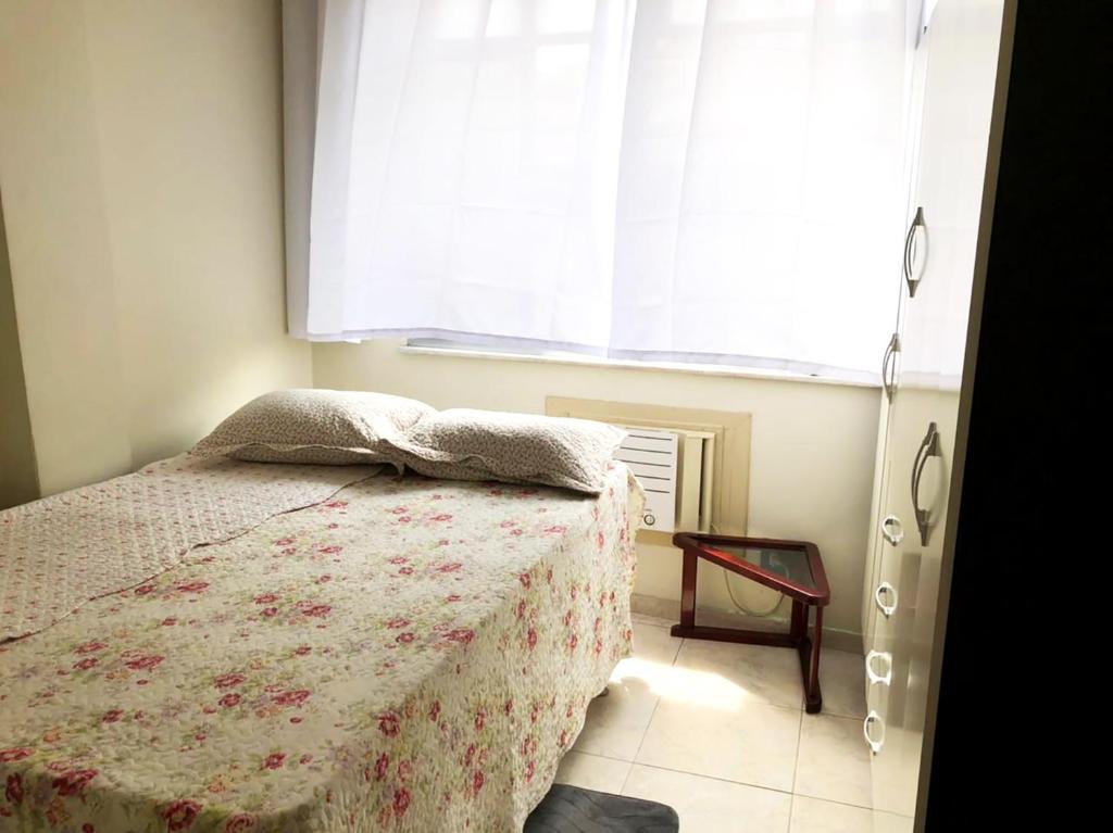 a bedroom with a bed and a large window at Apto perto das praias do Flamengo e do Botafogo in Rio de Janeiro