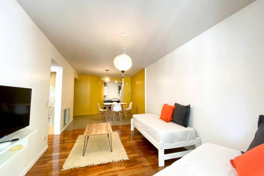 Exclusivo Loft En Recoleta Zona Clinicas Y Avenidas في بوينس آيرس: غرفة معيشة مع أريكة بيضاء وطاولة