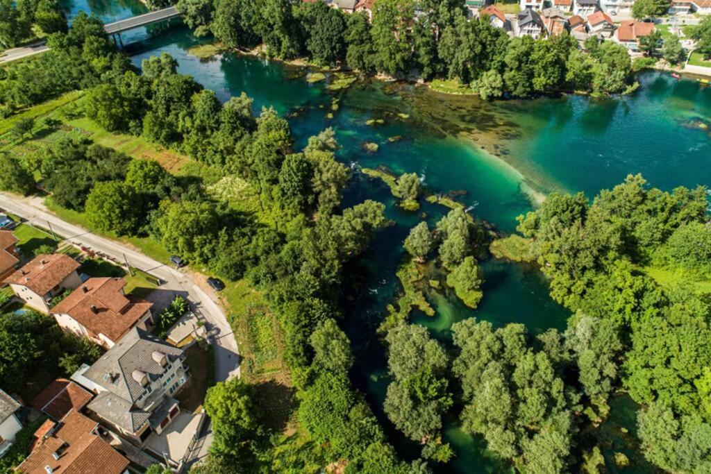 an aerial view of a river with trees and houses at apartment HOME in Bihać