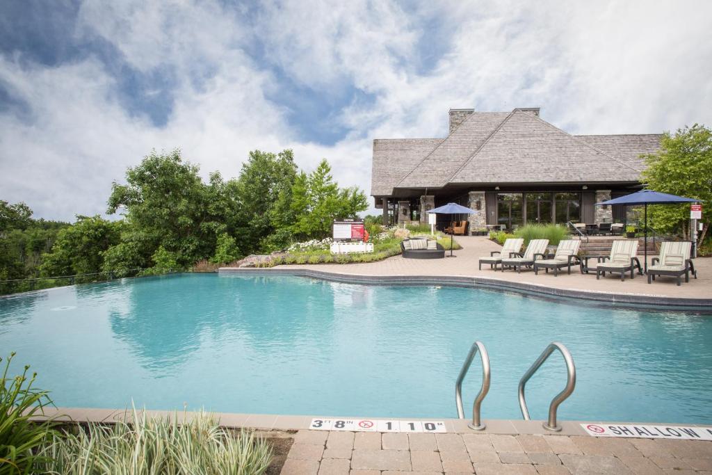 a swimming pool with two metal statues in front of a house at Muskoka Bay Resort in Gravenhurst