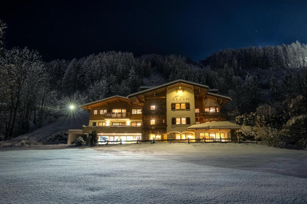 a large house in the snow at night at Residence Alpin in Zell am Ziller