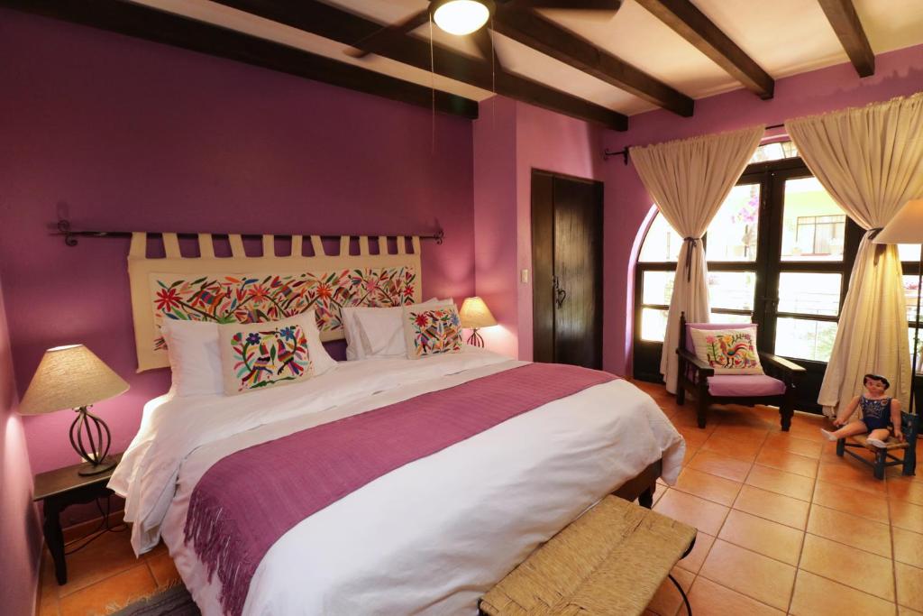 sypialnia z dużym łóżkiem i fioletowymi ścianami w obiekcie Casa Mia Suites w mieście San Miguel de Allende