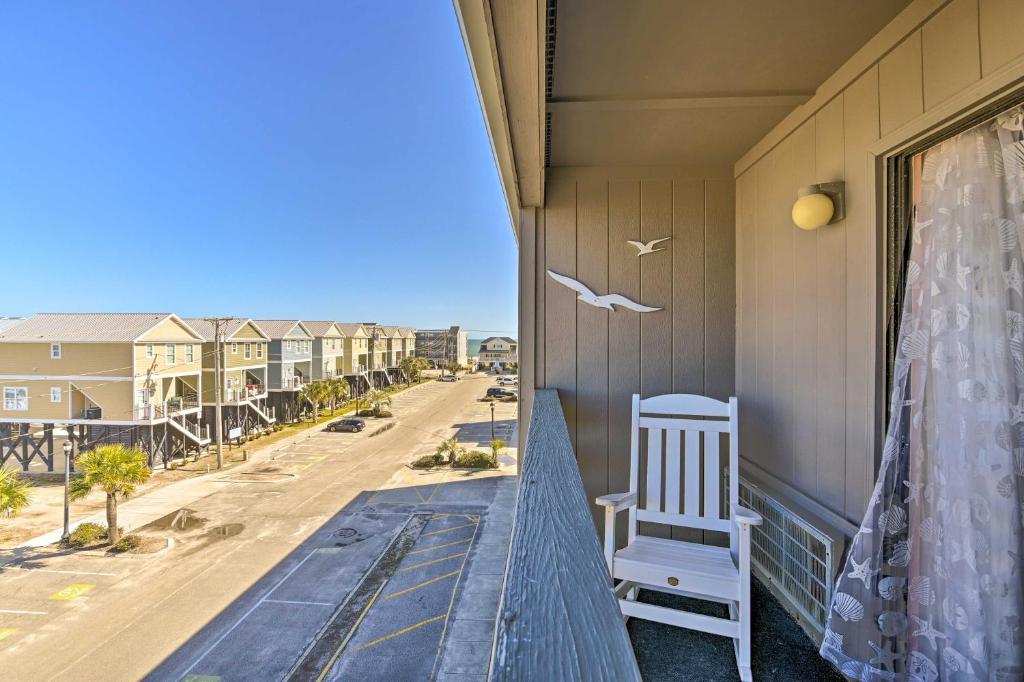 a balcony with a bench and a bird on a window at Beach Condo with Pool Access, 1 Block to the Ocean! in Myrtle Beach