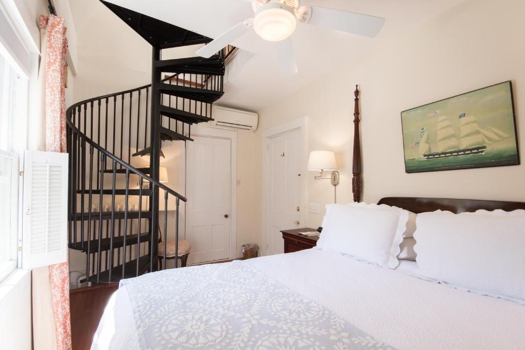 a bedroom with a white bed and a staircase at Marshall Slocum Inn in Newport