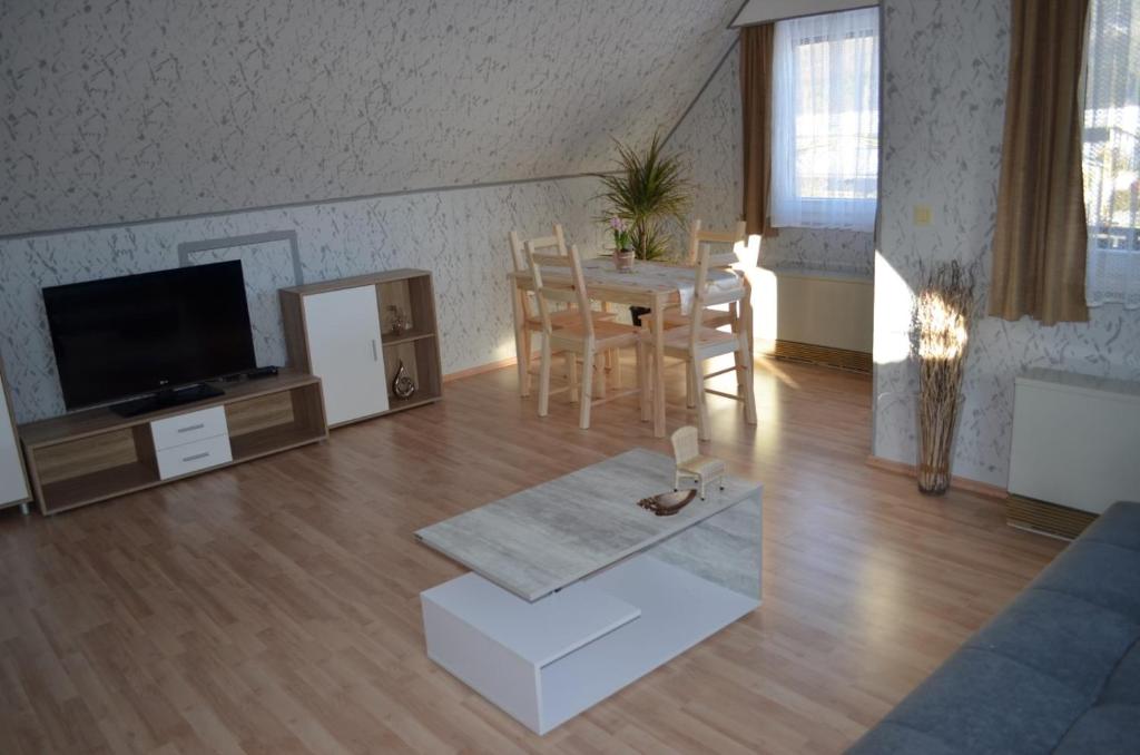 ein Wohnzimmer mit einem Tisch und einem TV in der Unterkunft Apartment da Elisa in Rietheim-Weilheim