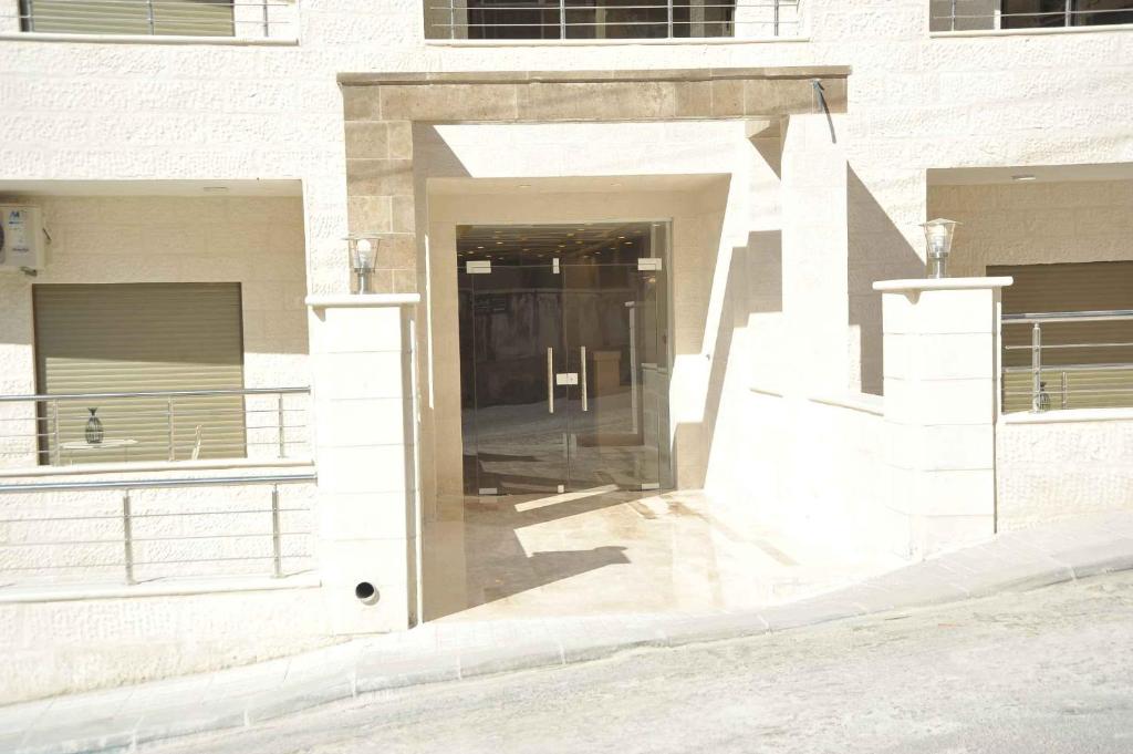 un bâtiment avec une porte au milieu d'une rue dans l'établissement Amazing one Bedroom Apartment in Amman Elwebdah 6, à Amman