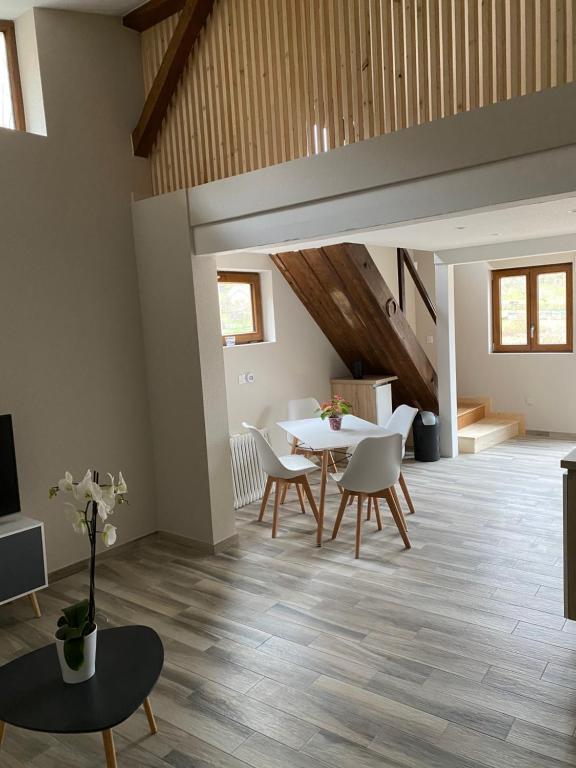 sala de estar con mesa de comedor y sillas en L'ECURIE du Château en Lebétain