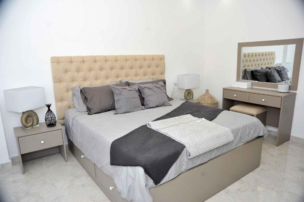 a bedroom with a large bed and two night stands at Amazing one Bedroom Apartment in Amman Elwebdah 4 in Amman