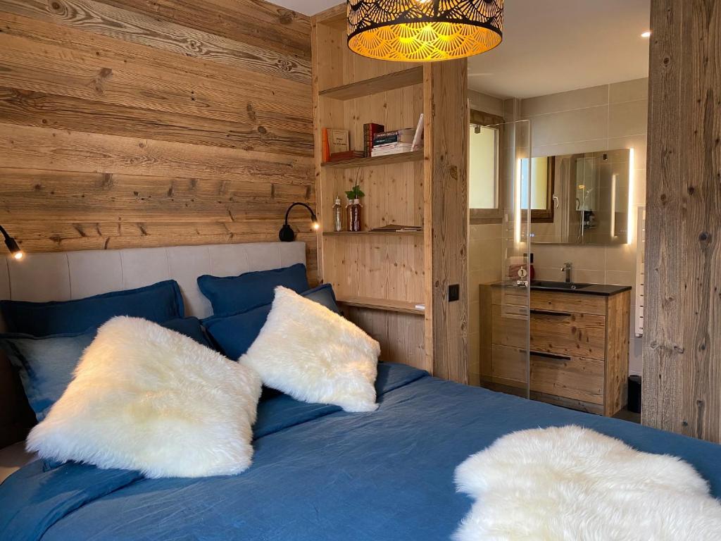 梅傑夫的住宿－A place 2 be, Megève centre，一间卧室配有蓝色的床和2个白色枕头